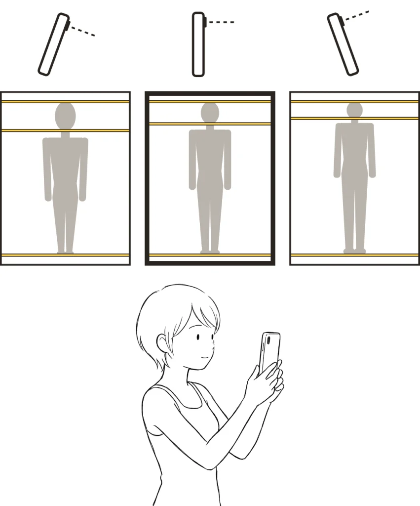 下に傾けた・まっすぐ・上に傾けたスマホと、それぞれで撮った写真の写り方の違い。下に、スマホを縦にまっすぐ構える女性